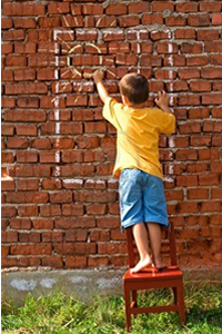 Niño pintando una ventana sobre un muro como símbolo de la educación